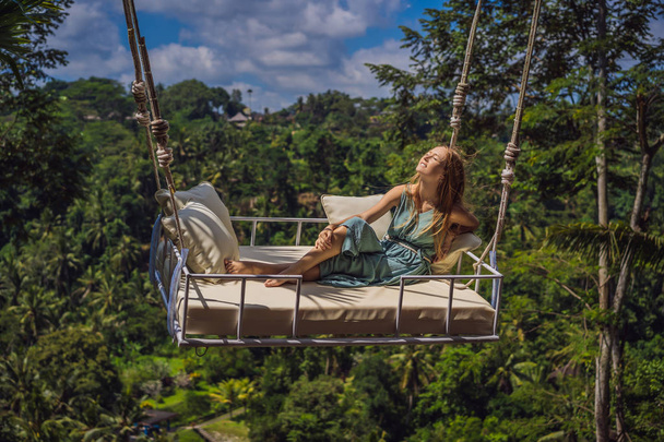 Young woman swinging in the jungle rainforest of Bali island, Indonesia. Swing in the tropics. Swings - trend of Bali - Foto, Imagem