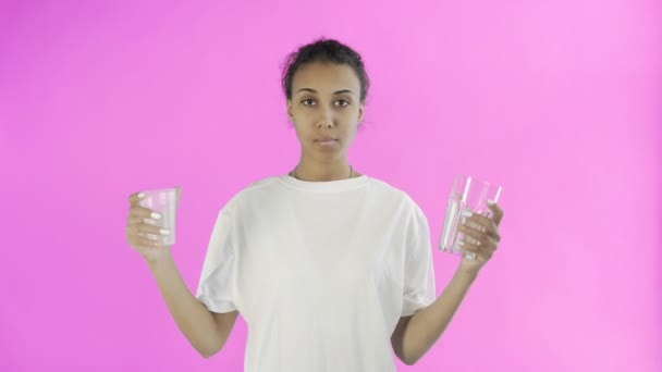 Afro-American Girl Activist With plastic and glass cups on pink background - Filmati, video