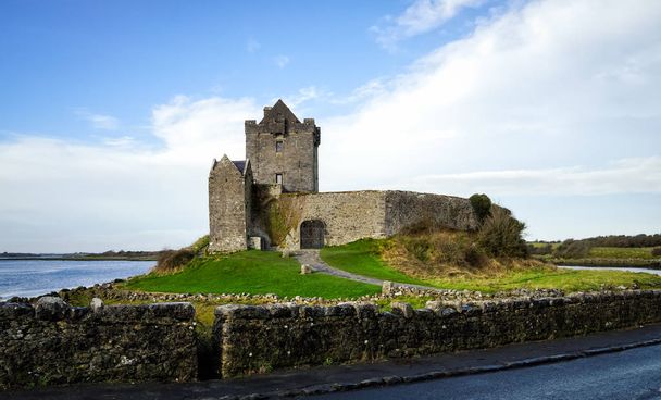 Ruinas del antiguo castillo de Dunguaire con hierba verde, arroyo y lago, Irlanda
 - Foto, Imagen
