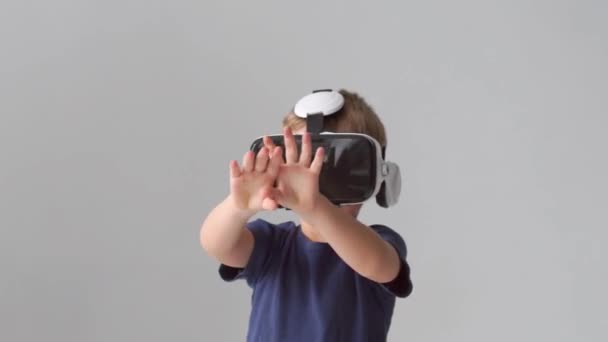 Portrait of happy boy in a virtual reality headset. Kid using vr goggles at home. Entertainment technology, futuristic gadgets and generation Z concept. - Filmati, video