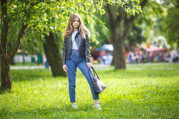 portrait of little beautiful stylish kid girl in city park on green forest background - Fotoğraf, Görsel