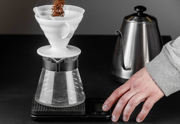 Alternative method of making coffee. coffeemaker is a manual pour-over style glass. Cofee brewing on black background - 写真・画像
