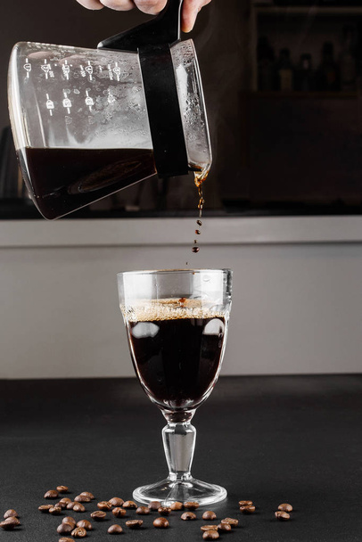 Alternative method of making coffee. coffeemaker is a manual pour-over style glass. Cofee brewing on black background - 写真・画像