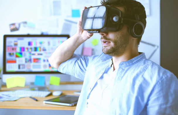 Young male software programmer testing a new app with 3d virtual reality glasses in office. - Φωτογραφία, εικόνα