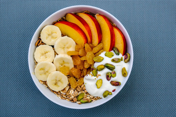 Tigela de café da manhã vegetariano saudável de frutas Muesli e nozes com sultanas
 - Foto, Imagem