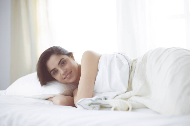 Mujer bonita acostada en su cama en casa - Foto, Imagen