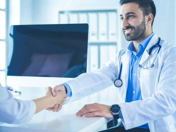 Doctor shaking hands to patient in the office at desk - Photo, image