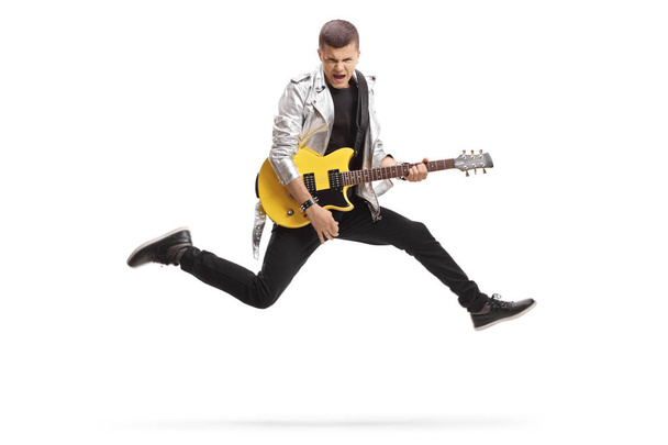 Young male guitarist jumping and playing - Valokuva, kuva