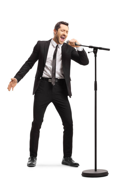Hombre de traje cantando en un micrófono
  - Foto, imagen