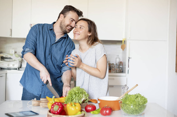 Портрет влюбленной молодой пары, готовящей еду
 - Фото, изображение