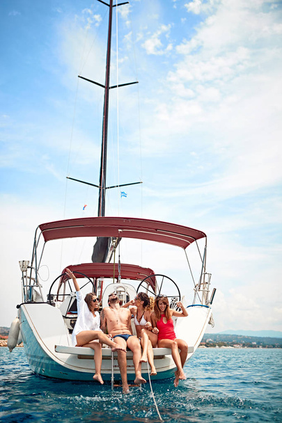 Group of friends relaxing on the yacht deck and laughing on vacation - Φωτογραφία, εικόνα