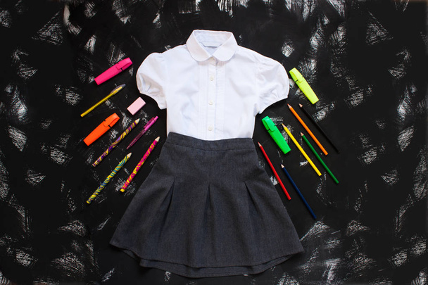 School uniform en stetionery op de zwarte achtergrond, terug naar school concept. - Foto, afbeelding
