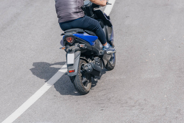 Biker indossa un gilet sta cavalcando la sua moto in salita su un su
 - Foto, immagini