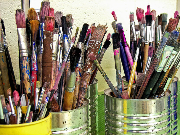 Close-up van gebruikte Artist paint brushes in blikken - Foto, afbeelding