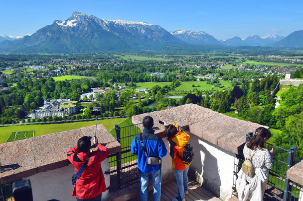 tourists take pictures the neighborhood of Salzburg from the height of the watchtower of Hohensalzburg Fortress, Salzburg, Austria - Photo, Image