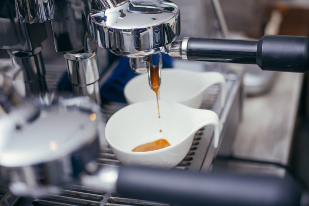 Kaffeemaschine, die Kaffee in eine Tasse gießt. Eine Nahaufnahme - Foto, Bild