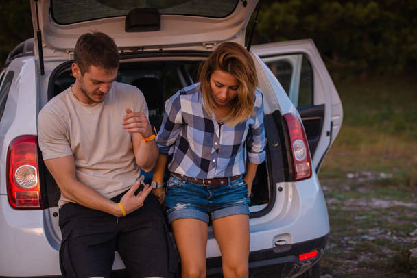 Jeune couple assis à l'arrière d'un véhicule hors route et profitant de la vue de l'intérieur du véhicule tout terrain au coucher du soleil
. - Photo, image