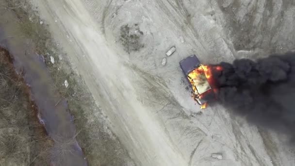 Blick von oben auf das graue Feld, wo riesige Flammen das Auto vollständig verbrennen und schwarzer Rauch aufsteigt - Filmmaterial, Video