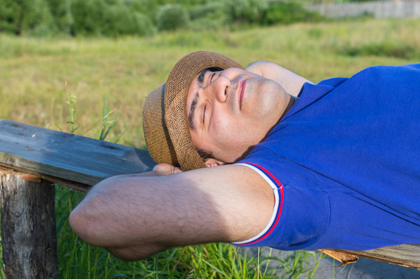 hombre duerme en un banco al aire libre
 - Foto, Imagen