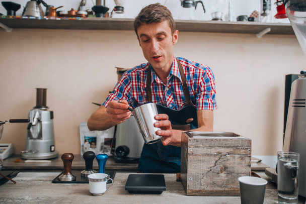 Καφές με χέρι. Μπάρμαν που ρίχνει καφέ από ασημένια τσαγιέρα - Φωτογραφία, εικόνα