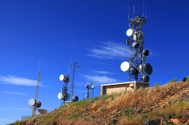 Wysokie wieże komunikacyjne przed błękitnym niebem - Zdjęcie, obraz