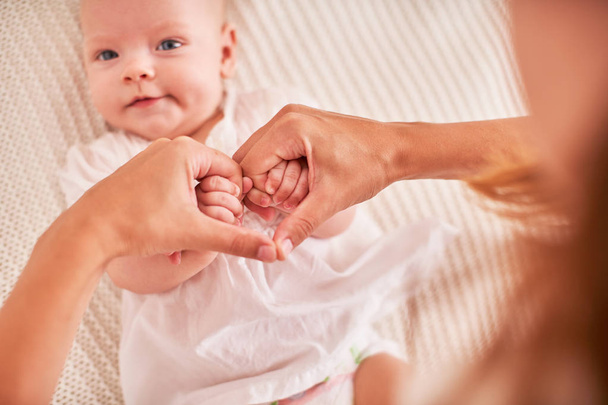 τα χέρια της μητέρας που κρατάνε τα χέρια του μωρού. διπλωμένο σύμβολο της καρδιάς και  - Φωτογραφία, εικόνα