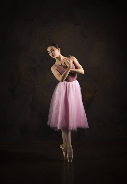 A slender girl in a pink skirt and beige top dancing ballet. - Foto, Imagem