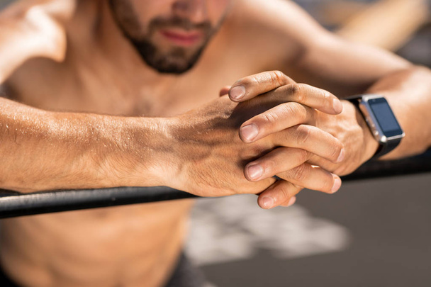 Hands of young shirtless athlete over sportsbar during workout or rest after training outdoors - Фото, зображення