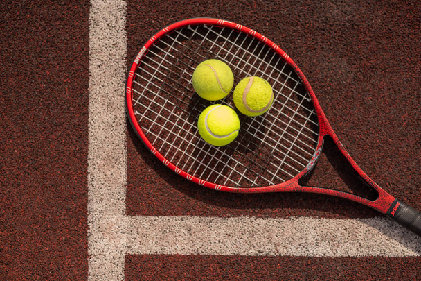 Vista superior de três bolas de tênis em raquete por linha branca de playground esportivo
 - Foto, Imagem