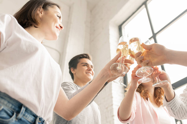 Onnellinen rento ystävät clinking kanssa huilut samppanjaa juhliessaan elämän tapahtuma kotona puolue yhdessä
 - Valokuva, kuva