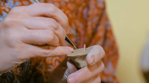 Donna vasaio fare ceramica souvenir penny fischietto in laboratorio di ceramica
 - Foto, immagini