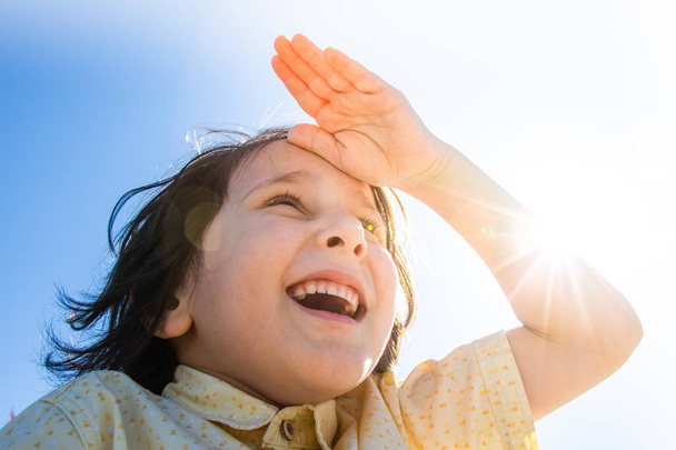 Alnında el ile parlama güneş içinde Mutlu gülümseyen çocuk - Fotoğraf, Görsel