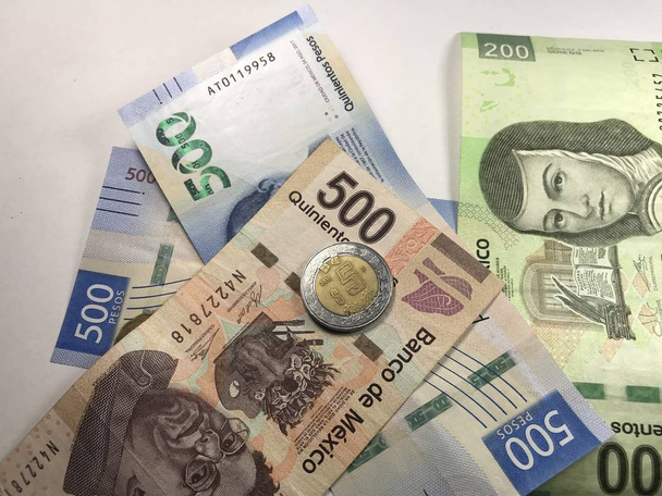Mexicaanse peso rekeningen verspreid over witte achtergrond - Foto, afbeelding