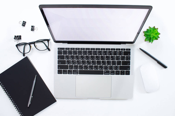 Escritorio de oficina blanco de estilo moderno con computadora portátil, gafas y portátil
 - Foto, imagen