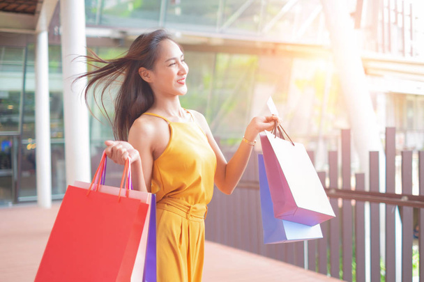 Beautiful women with shopping bags and credit card enjoying in shopping standing outdoors of shopping mall, shopping concept - 写真・画像