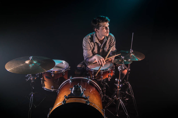 muzikant speelt drums, zwarte achtergrond en mooie zachte LIGH - Foto, afbeelding