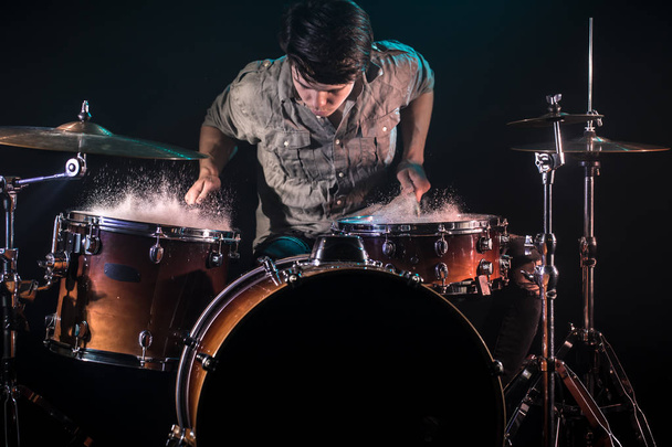 musician playing drums with splashes, black background with beau - Foto, imagen