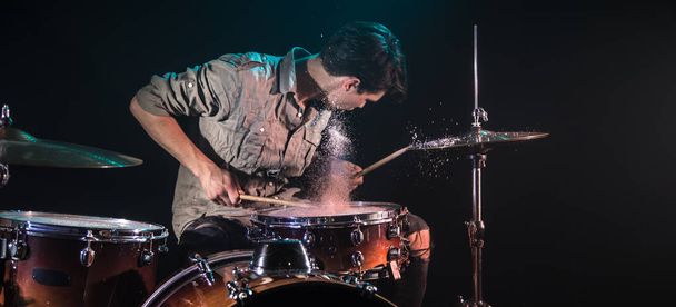 muzikant speelt drums met spatten, zwarte achtergrond met Beau - Foto, afbeelding