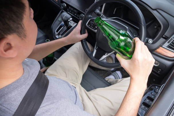 ドライブのコンセプトのために飲んではいけません, 若い酔っ男飲むボトル o - 写真・画像