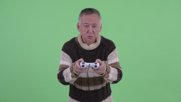Tired mature Japanese man playing games and falling asleep - Footage, Video