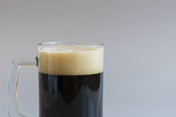 Glas dunkles Bier auf grauem Hintergrund. Kopierraum - Foto, Bild