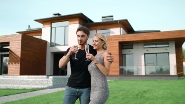 Boldog pár iszik pezsgőt közel luxus otthon együtt. - Felvétel, videó