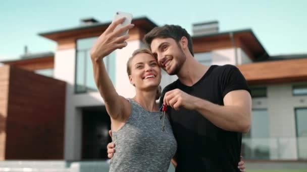Felice coppia fare foto selfie con chiavi di casa fuori residenza
. - Filmati, video