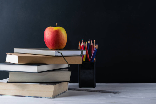 Back to school background with books and apple on blackboard - Photo, Image