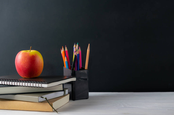 Volver a la escuela con libros y manzana en pizarra
 - Foto, Imagen