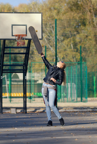 Hipster girl posing with a skateboard. - Fotó, kép