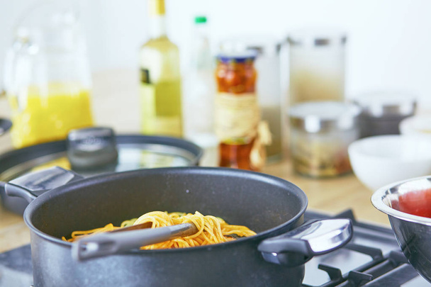 Ζυμαρικά κύλησε στο πιρούνι τηγάνι στο μάτι της κουζίνας στην κουζίνα - Φωτογραφία, εικόνα