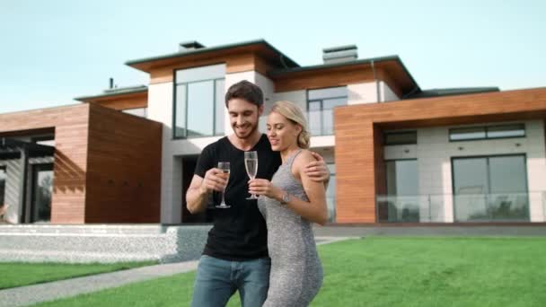 Úspěšný muž a žena popíjení šampaňského mimo luxusní dům. - Záběry, video