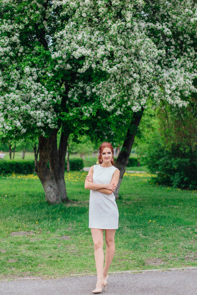 Charming woman wearing beautiful white dress under the apple tree - Foto, immagini