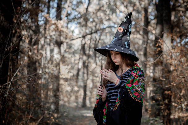 Halloween witch with a knife in the woods - Foto, afbeelding